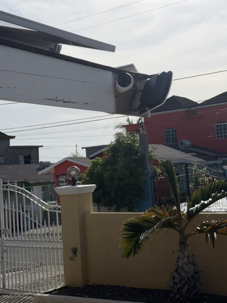 Security camera mounted under eave covering driveway and gate