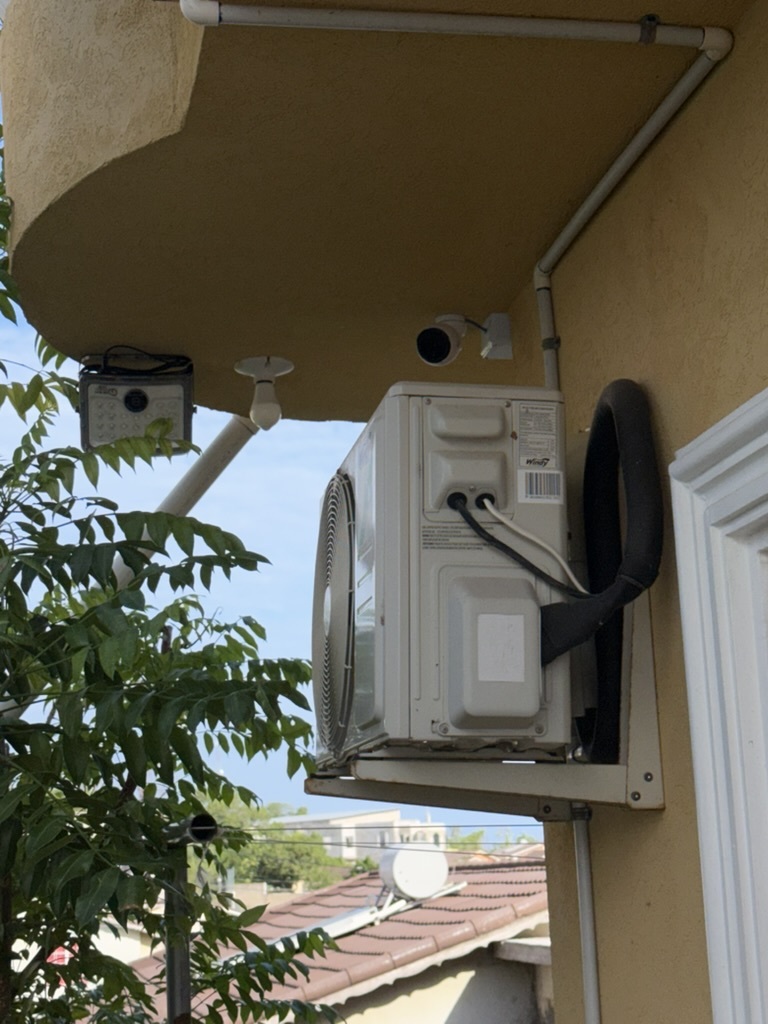 UniFi camera mounted above AC unit with clean conduit run