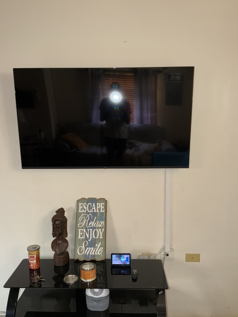 TV wall mount in living room with concealed wiring — Airbnb install